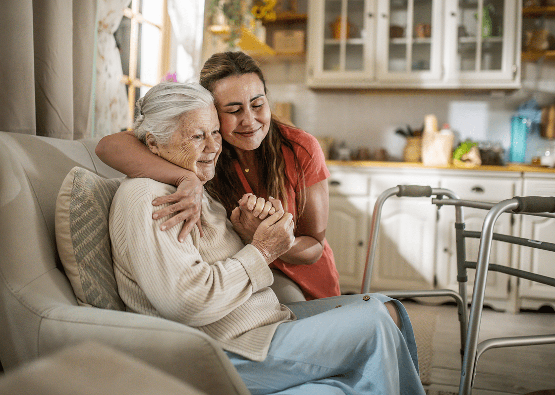 Daughter comforting elderly mother at home