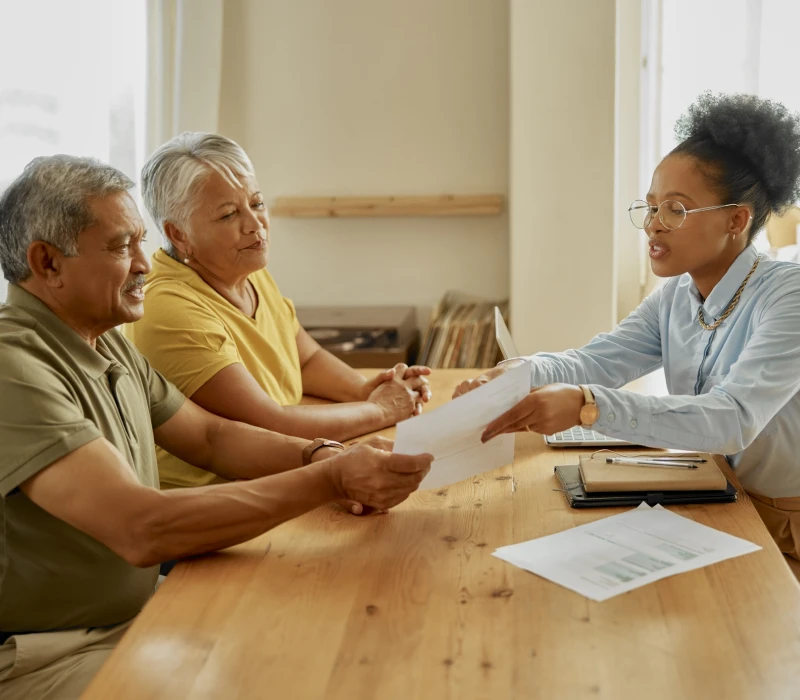 Senior couple discussing documents with advisor